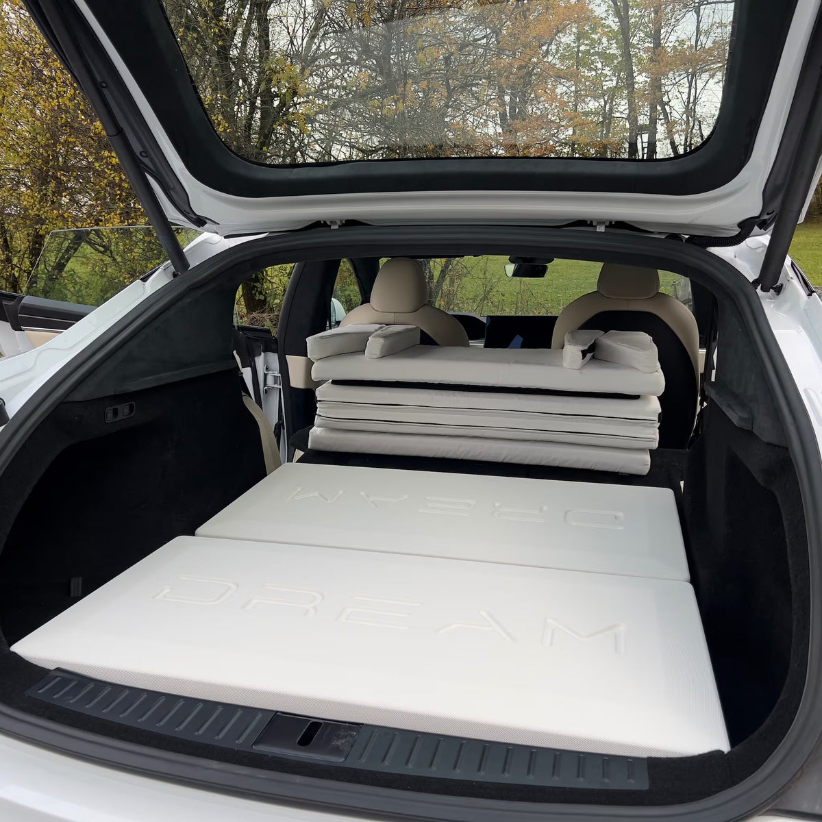 DreamCase white case unfolded into leveling bed platform in Tesla Model S trunk