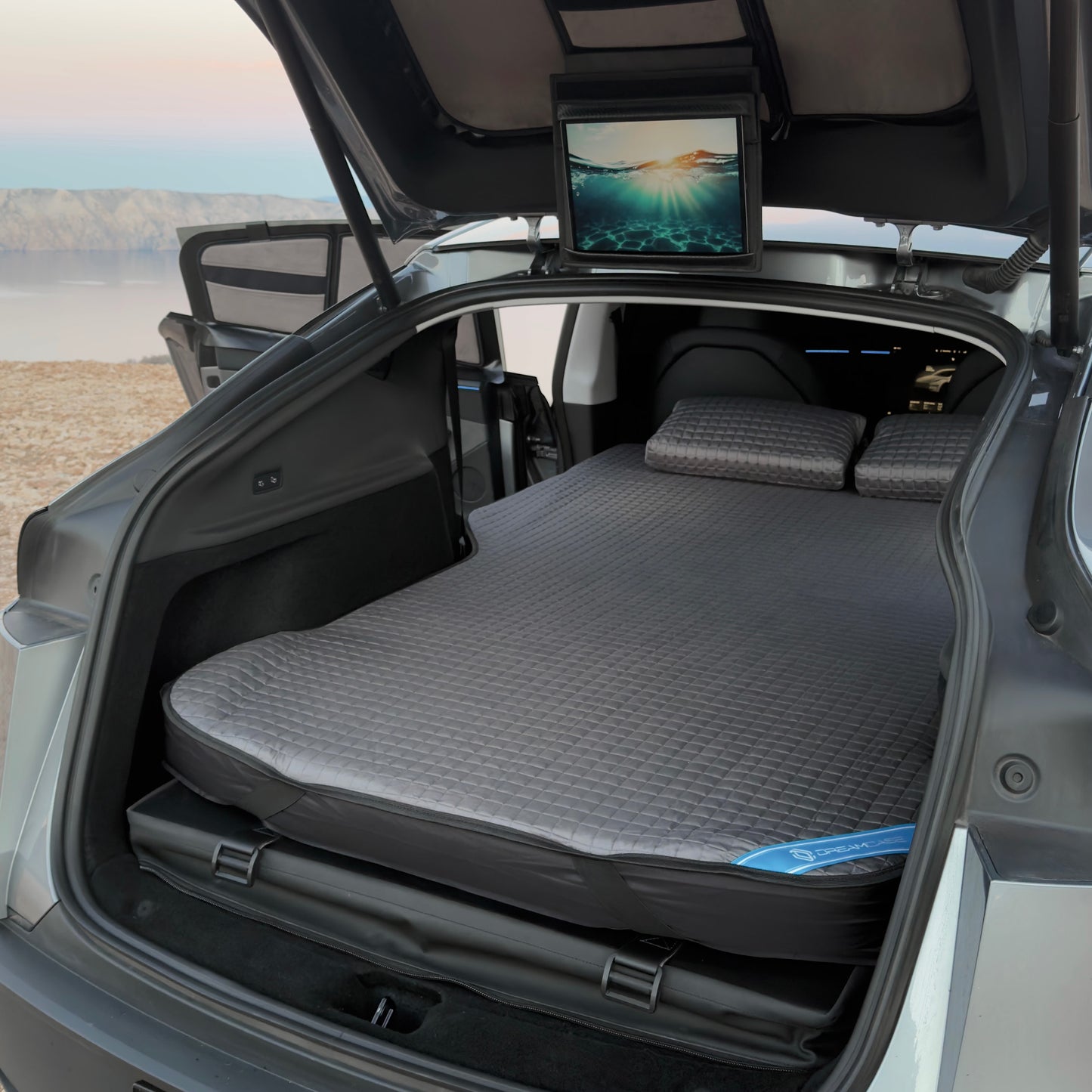 Grey DreamCase Air installed as a comfortable double bed in Tesla Model Y with quilted pillows
